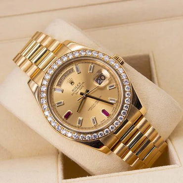 Rolex Day-Date II 218348 18ct Yellow Gold Factory Diamond Bezel & Ruby Dial Gold wristwatch with diamond bezel on a beige background