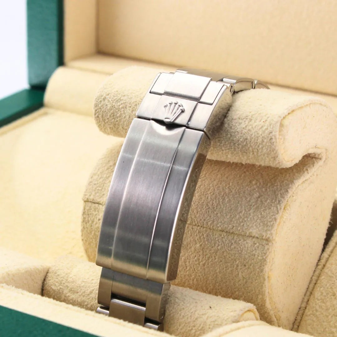 Rolex Submariner 116610LV Hulk Watch Silver watch band with Rolex logo on a beige cushion