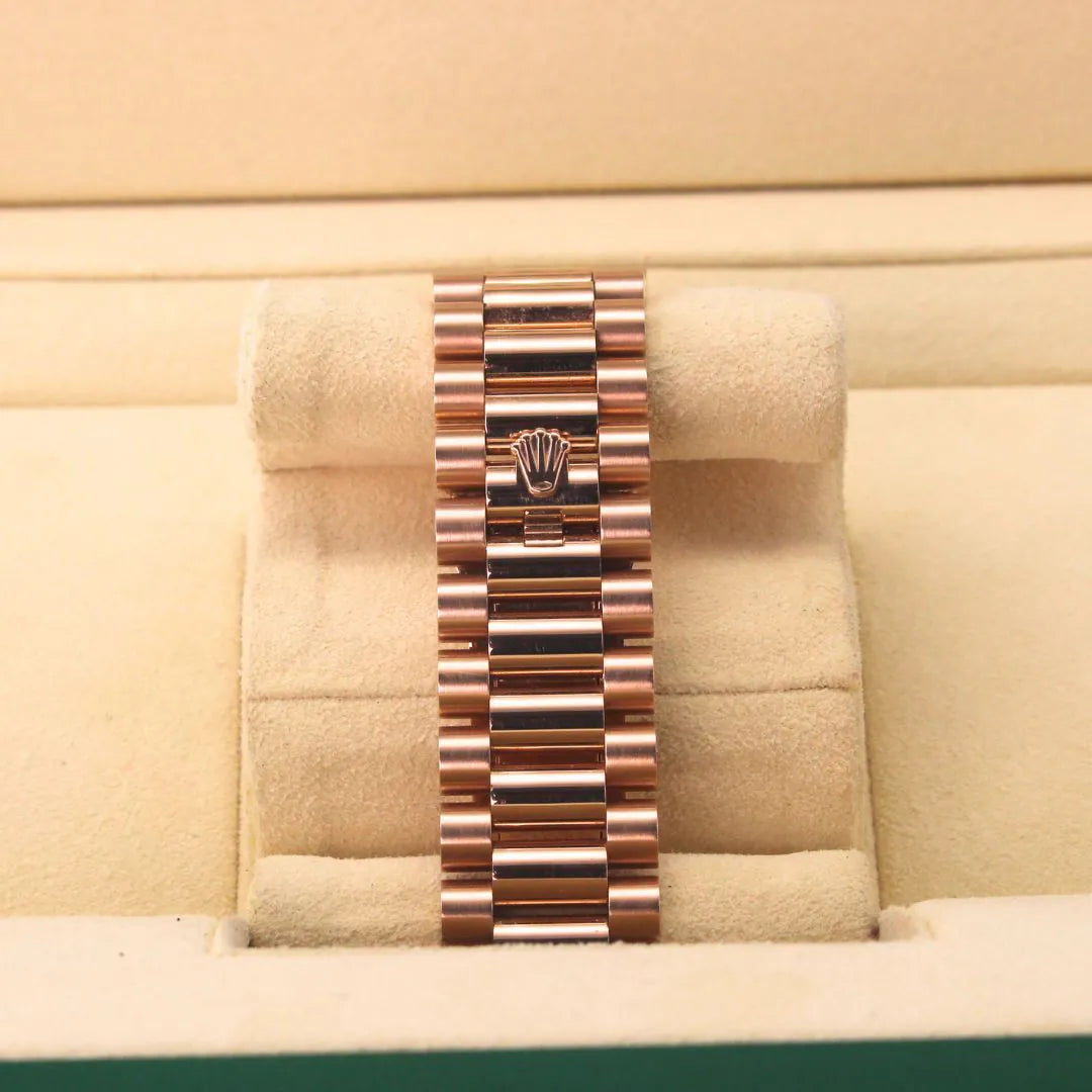 Rolex Day-Date 40 228235 Chocolate Motif Dial 18k Everose Gold Watch Rose gold watch in a display case with a beige background