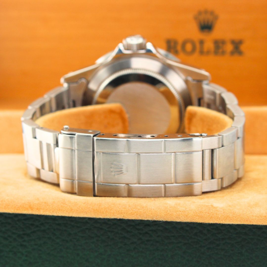 Rolex Submariner 16800 Watch Silver Rolex watch on a branded cushion with a visible Rolex logo.