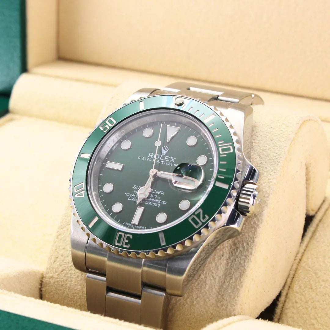 Rolex watch with green bezel and face on beige cushion