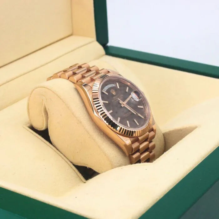 Rolex Day-Date 40 228235 Chocolate Motif Dial 18k Everose Gold Watch Rose gold watch with a dark face in an open green and beige box
