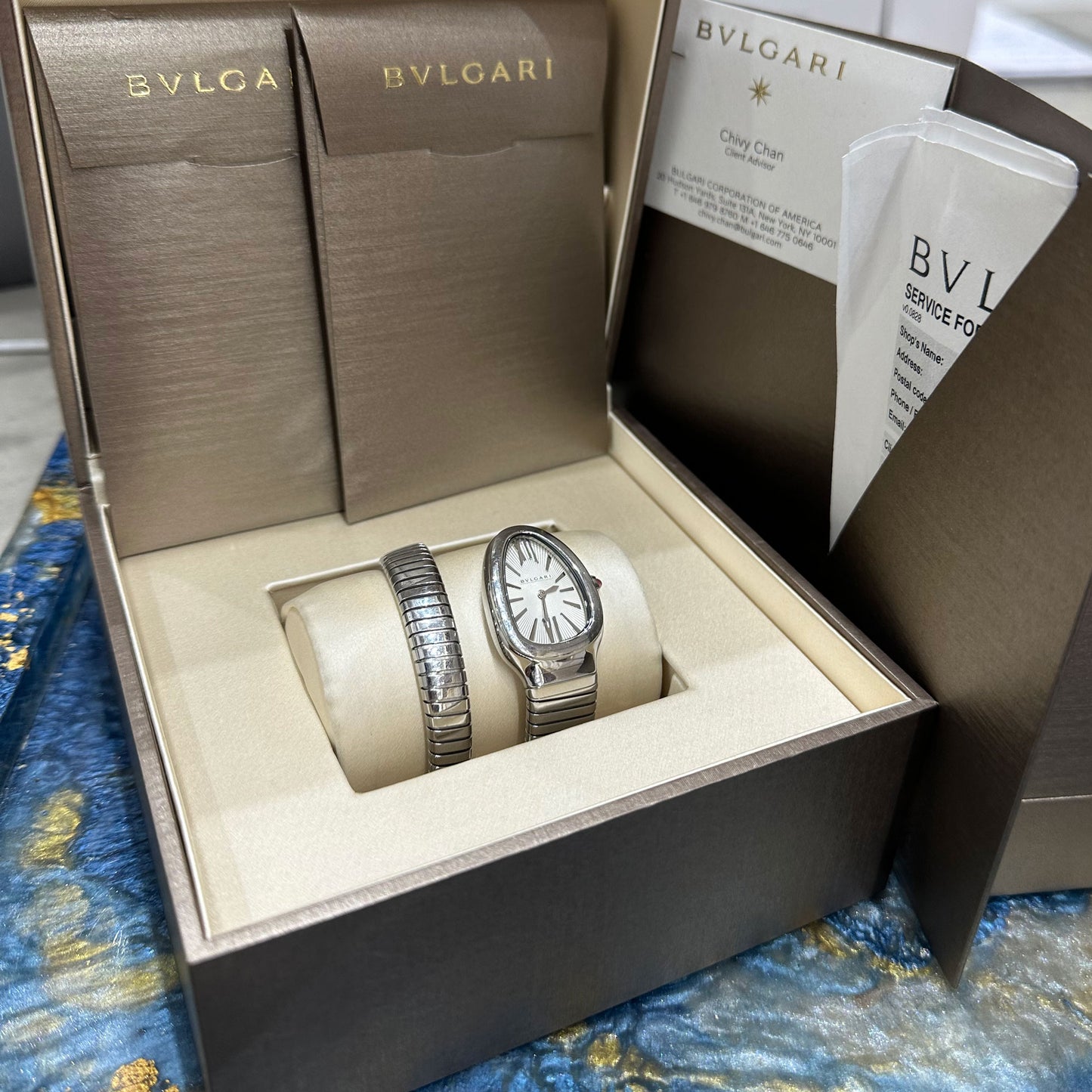 Bvlgari Serpenti Tubogas 101828 – Small 35mm White Dial Stainless Steel Ladies Watch Bulgari watch set in an open box with accessories on a patterned surface