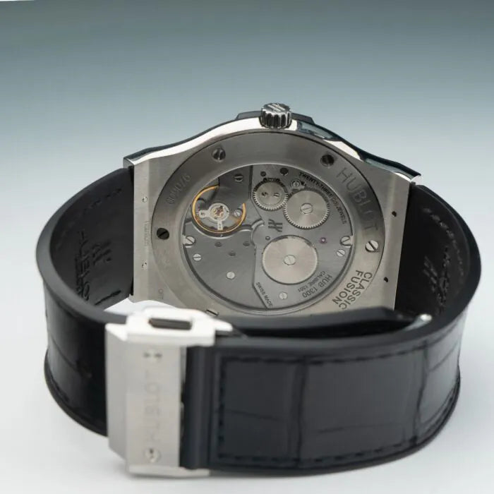 Hublot watch with black strap and silver case on a light gray background