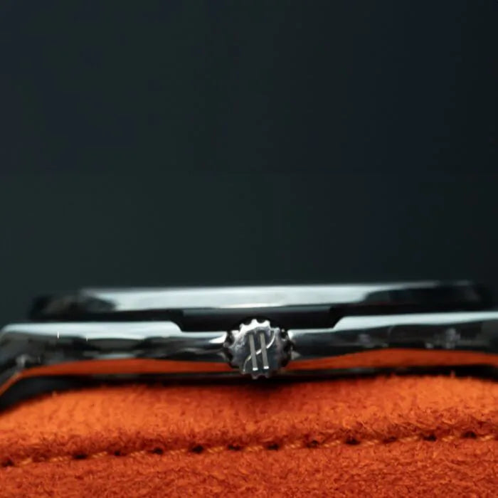 Hublot Classic Fusion Ultra-Thin 515.NX.1270.LR Titanium 45mm Black Dial Close-up of a silver bracelet with a decorative clasp on an orange surface.