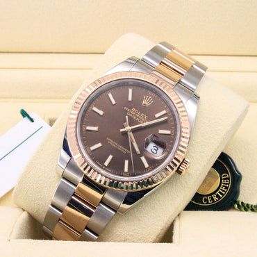 Rolex watch with brown dial on a beige cushion, with a certification card in the background.