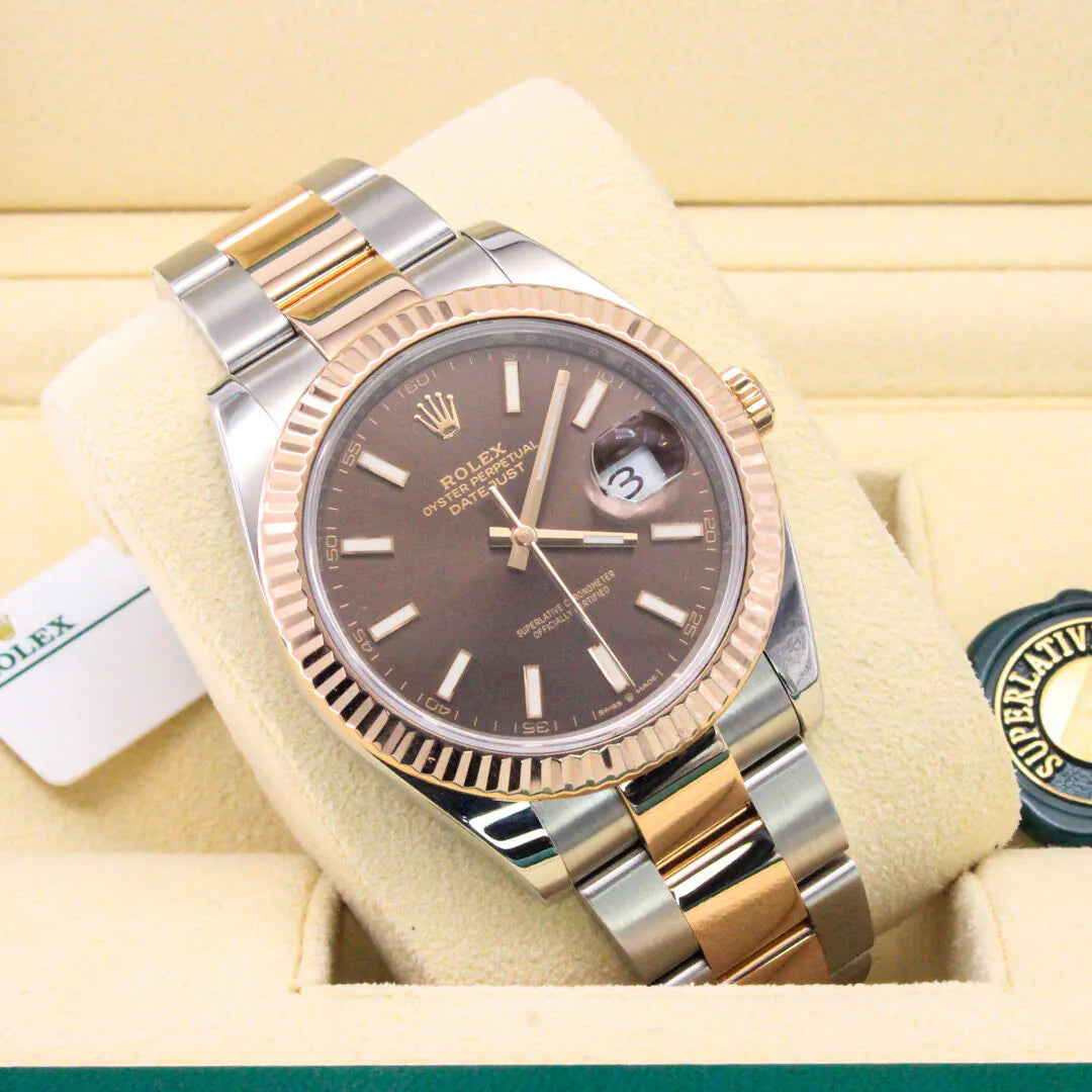 Rolex watch with two-tone metal band on a yellow background