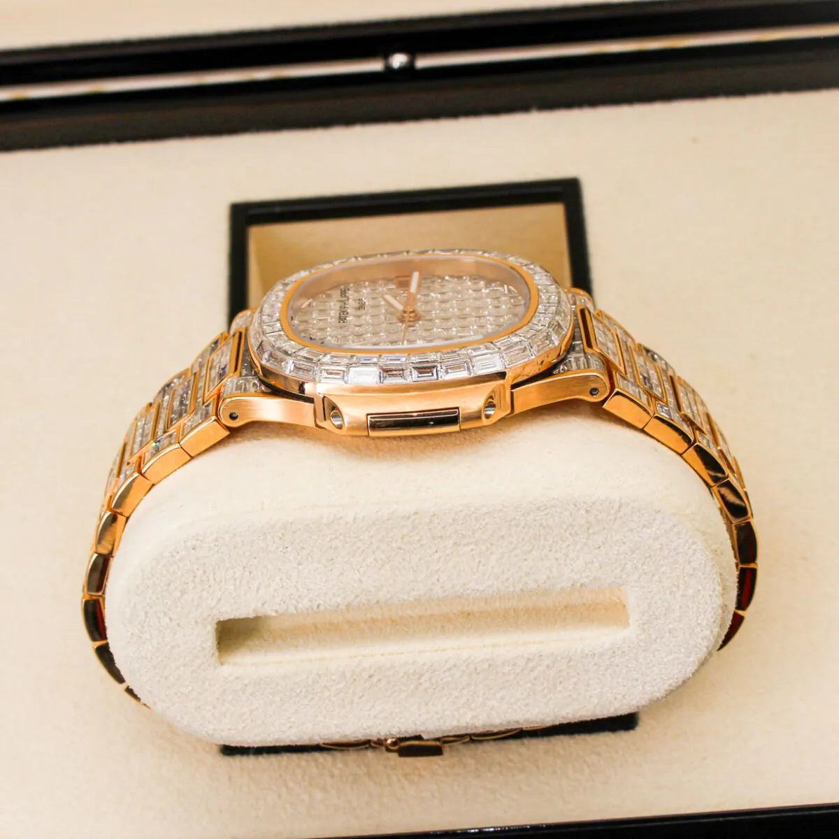 Patek Philippe Nautilus 5711/1R 18K Rose Gold Baguette Diamond Set  Luxury gold watch with diamond accents on a white cushion in a black box