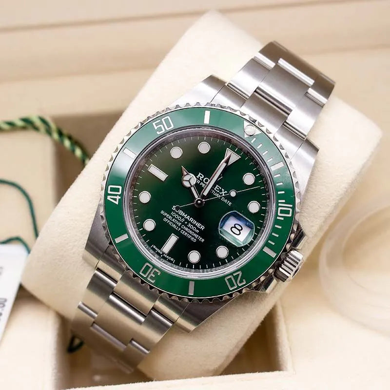 Rolex watch with green bezel and face on a beige cushion