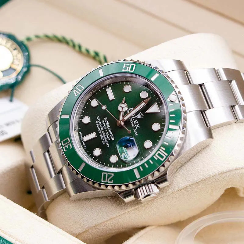 Rolex watch with green bezel and black face on a beige cushion