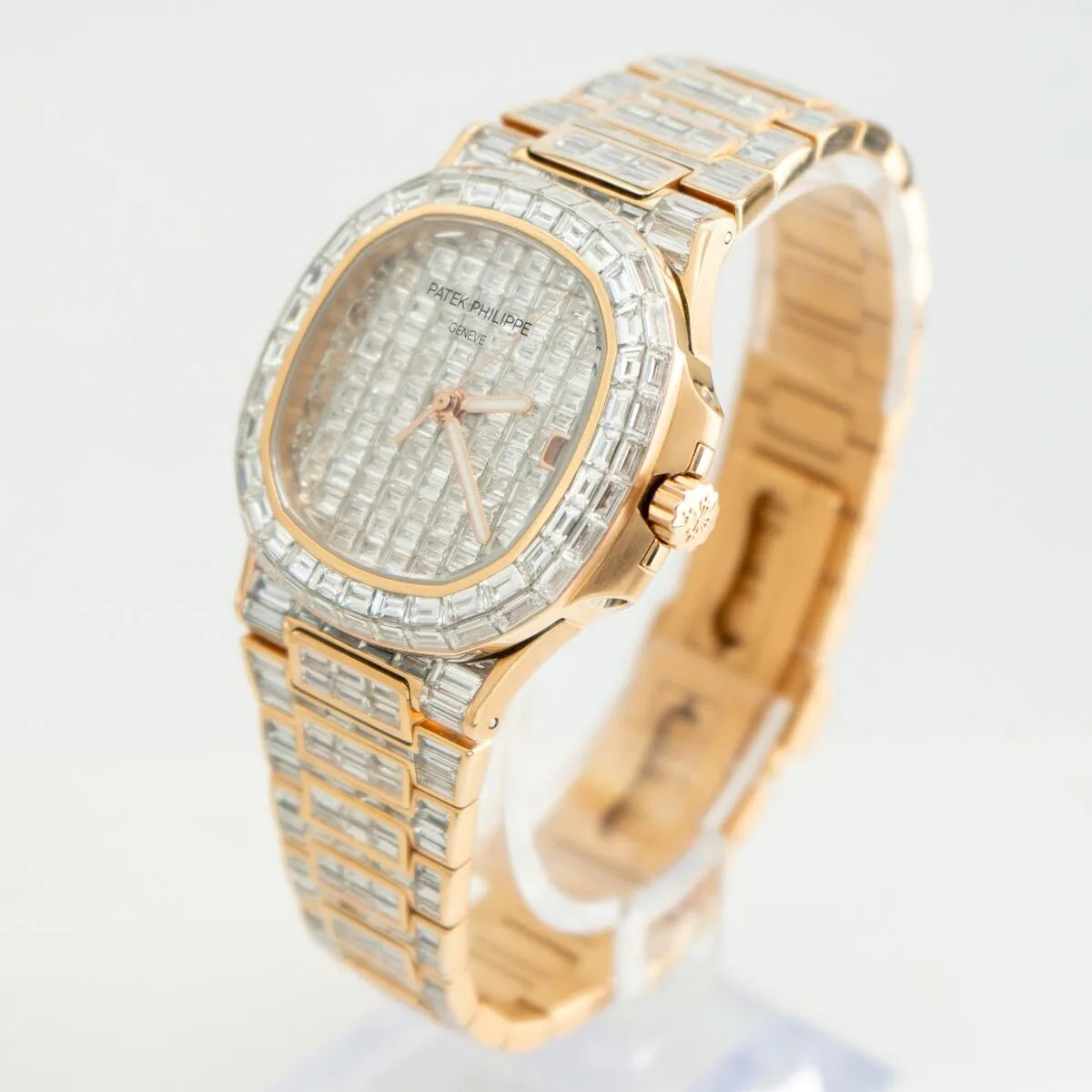 Patek Philippe Nautilus 5711/1R 18K Rose Gold Baguette Diamond Set  Gold and silver watch with diamond-studded bezel on a white background
