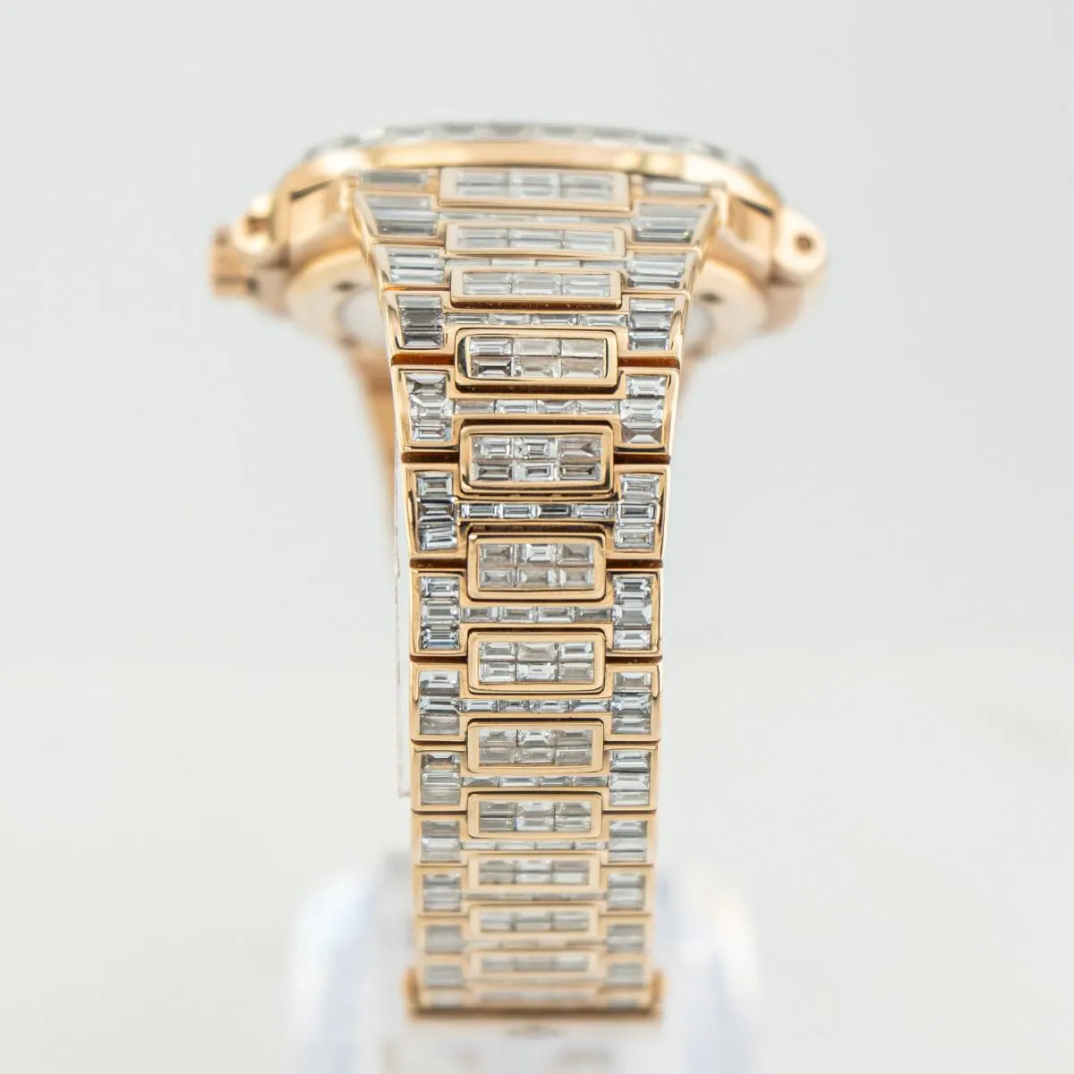 Patek Philippe Nautilus 5711/1R 18K Rose Gold Baguette Diamond Set  Rose gold watch with diamond-studded bracelet on a light gray background