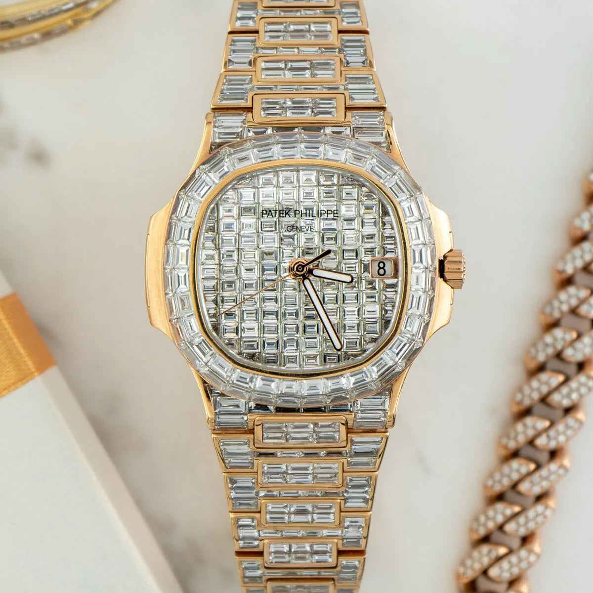 Patek Philippe Nautilus 5711/1R 18K Rose Gold Baguette Diamond Set  Gold and diamond-encrusted watch on a light background