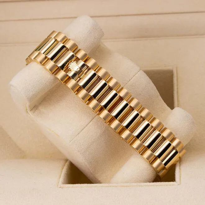 Rolex Day-Date II 218348 18ct Yellow Gold Factory Diamond Bezel & Ruby Dial  Gold bracelet on a beige cushion with a neutral background