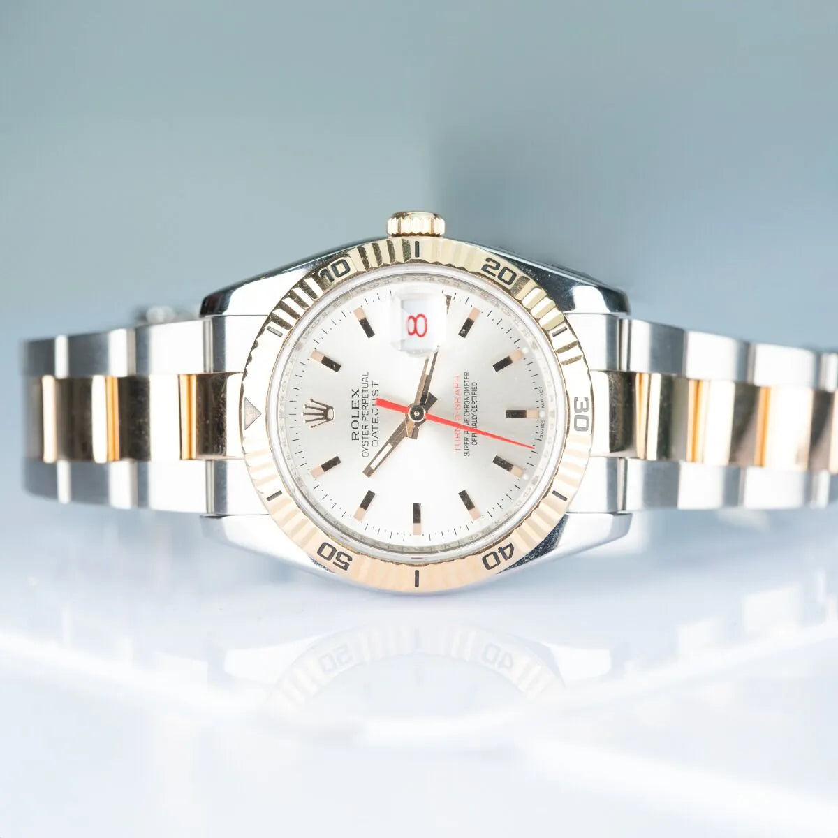 Rolex Datejust 116261 Turn O Graph Silver and gold watch with white face on a light blue background