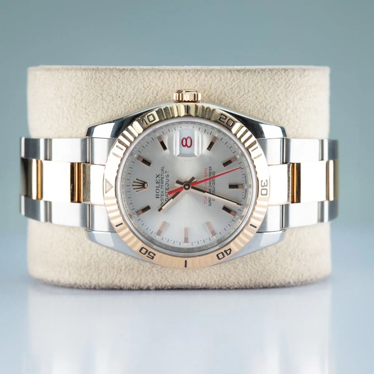 Rolex Datejust 116261 Turn O Graph Luxury watch with silver and gold band on a textured stand against a light gray background