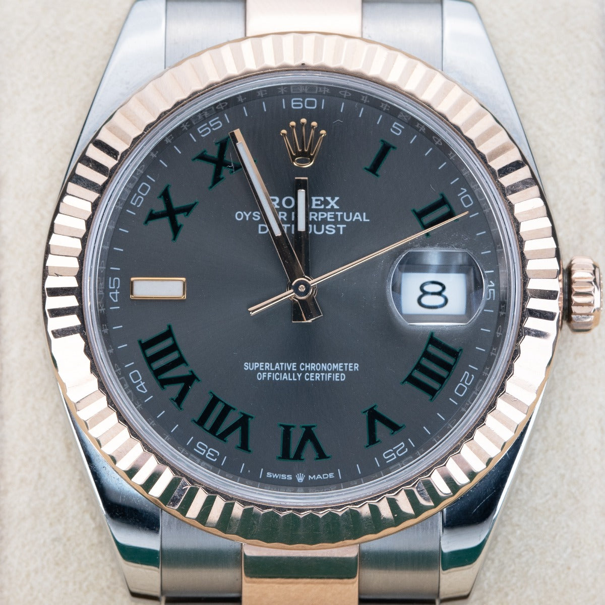 Rolex watch with silver and rose gold case on a light gray background