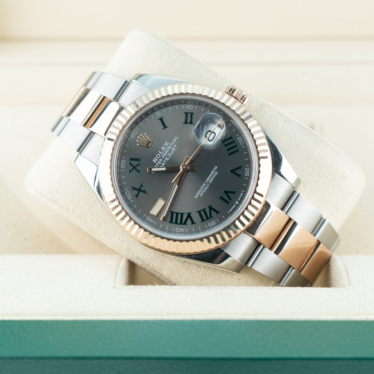 Luxury watch with silver and rose gold band on a light background