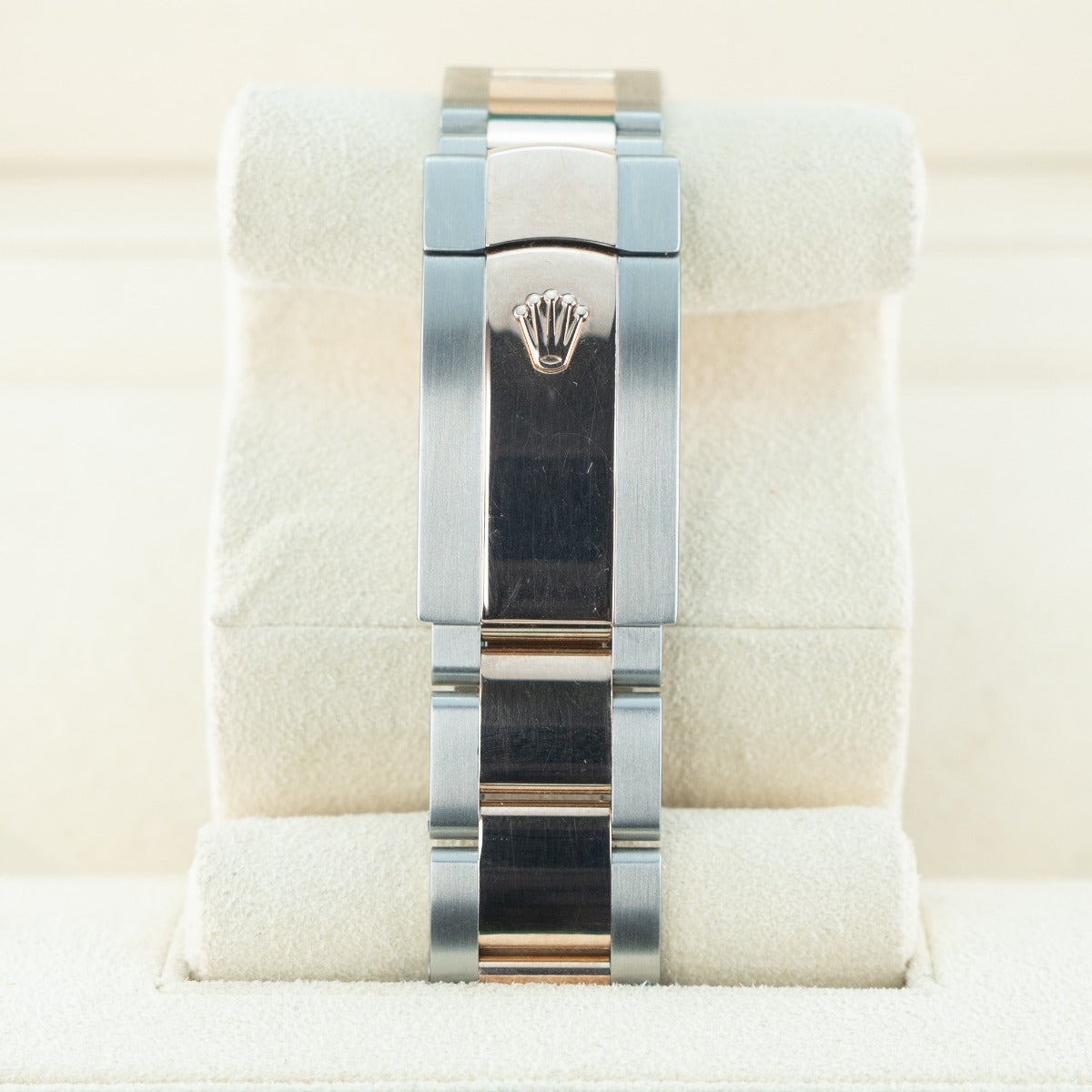 Silver watch band with Rolex logo on a white cushion